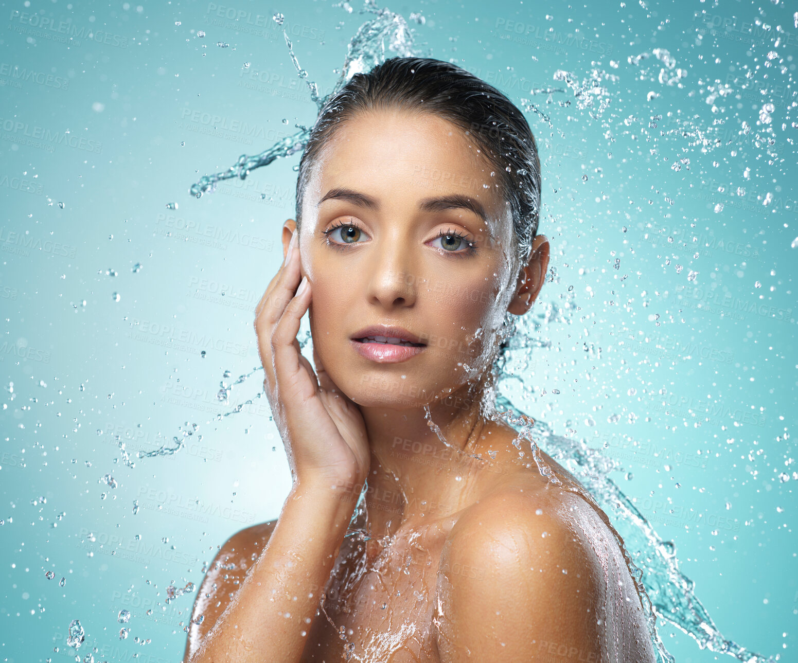 Buy stock photo Shot of a young woman taking a shower against a blue background