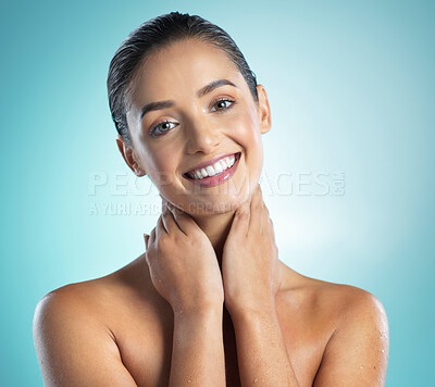 Buy stock photo Shot of a young female touching a her soft skin against a blue background