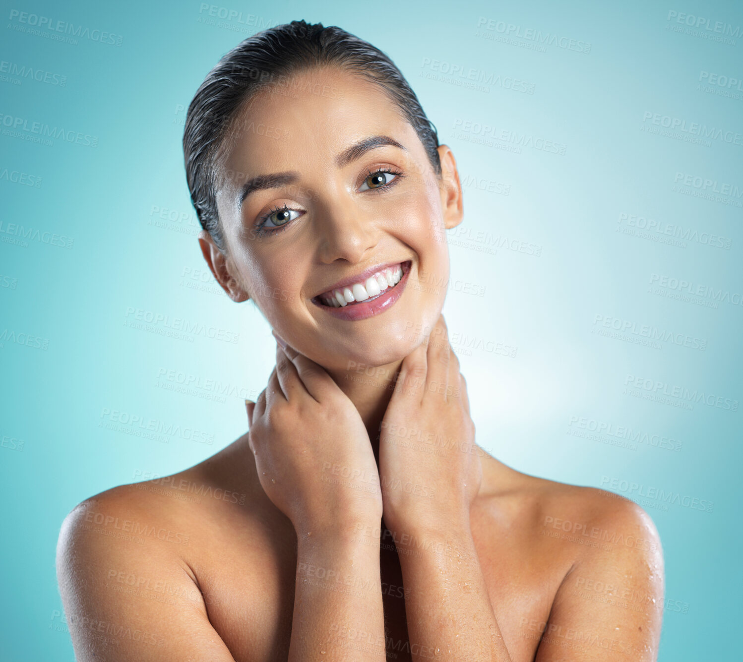 Buy stock photo Shot of a young female touching a her soft skin against a blue background