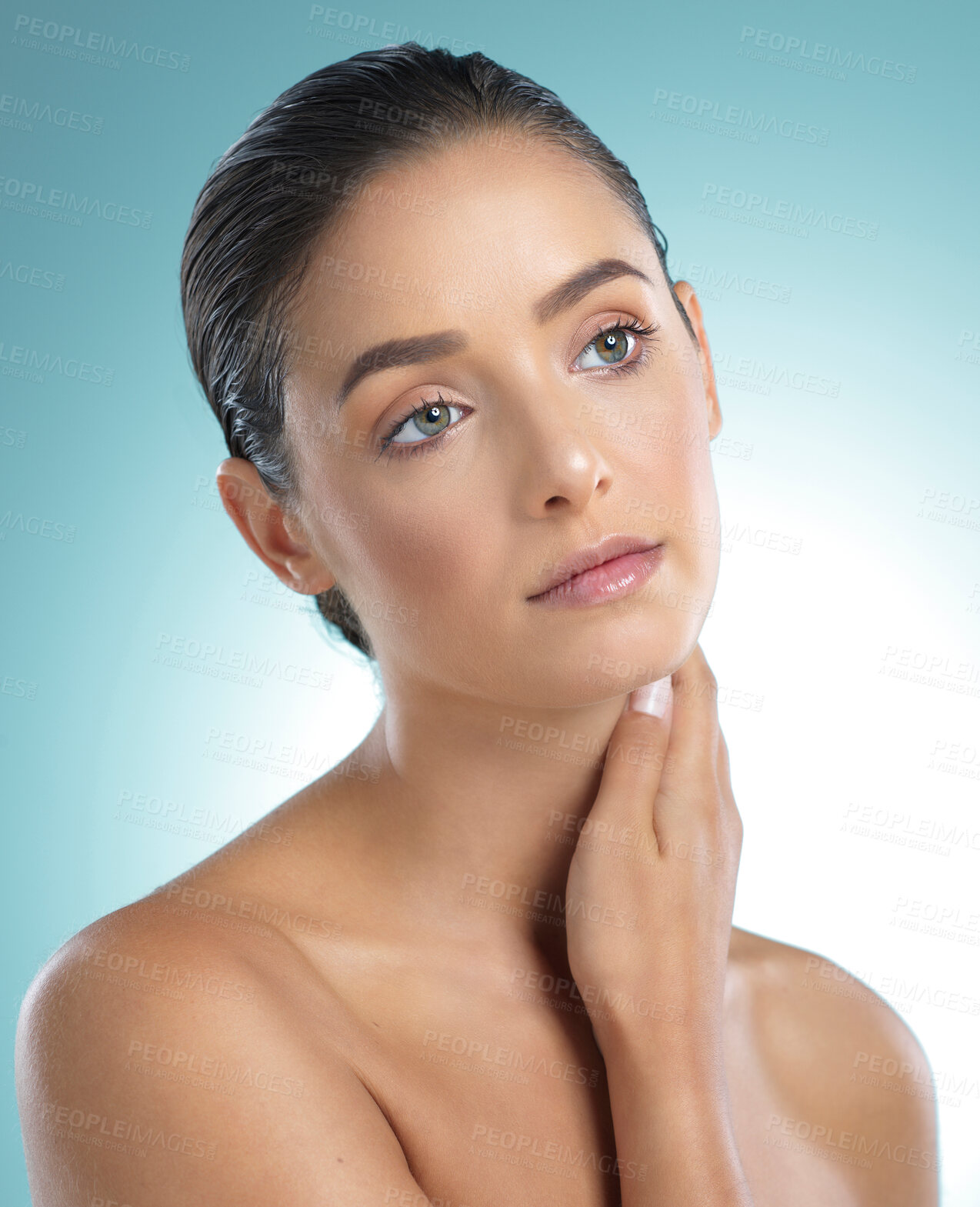 Buy stock photo Shot of a young female touching a her soft skin against a blue background