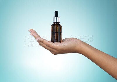 Buy stock photo Shot of a young woman taking serum from a dropper against a grey background