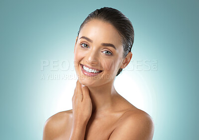 Buy stock photo Shot of a young female touching a her soft skin against a blue background