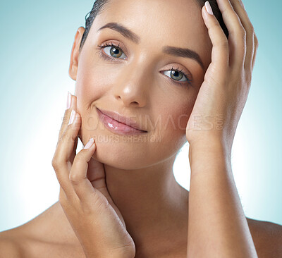 Buy stock photo Shot of a young female touching a her soft skin against a blue background