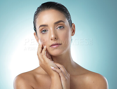 Buy stock photo Shot of a young female touching a her soft skin against a blue background