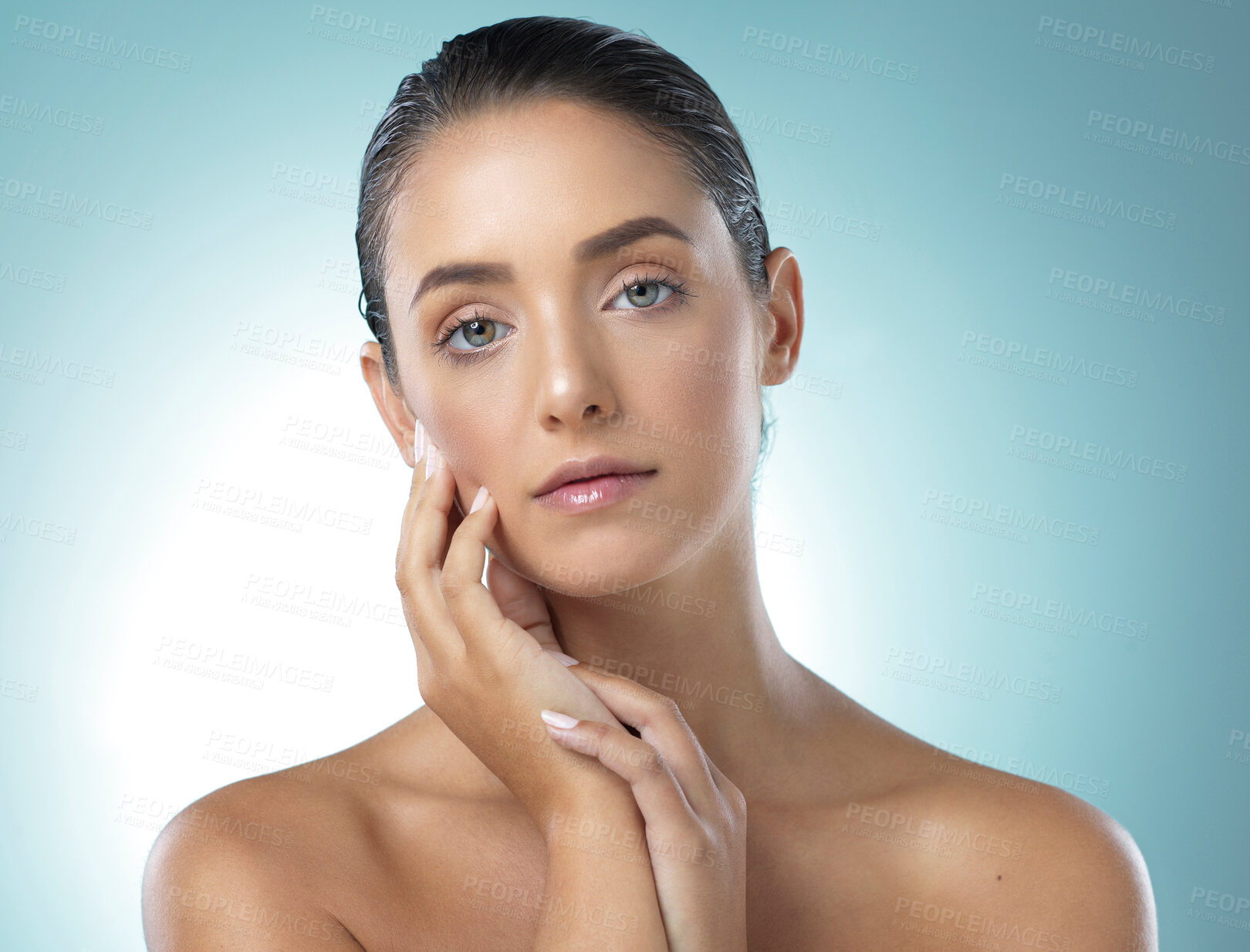 Buy stock photo Shot of a young female touching a her soft skin against a blue background