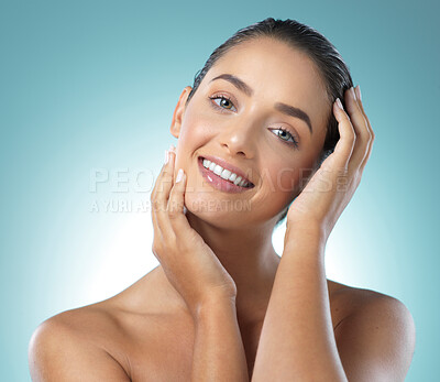 Buy stock photo Shot of a young female touching a her soft skin against a blue background