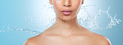 Buy stock photo Cropped shot of an unrecognisable woman posing against a blue background in the studio while being splashed with water