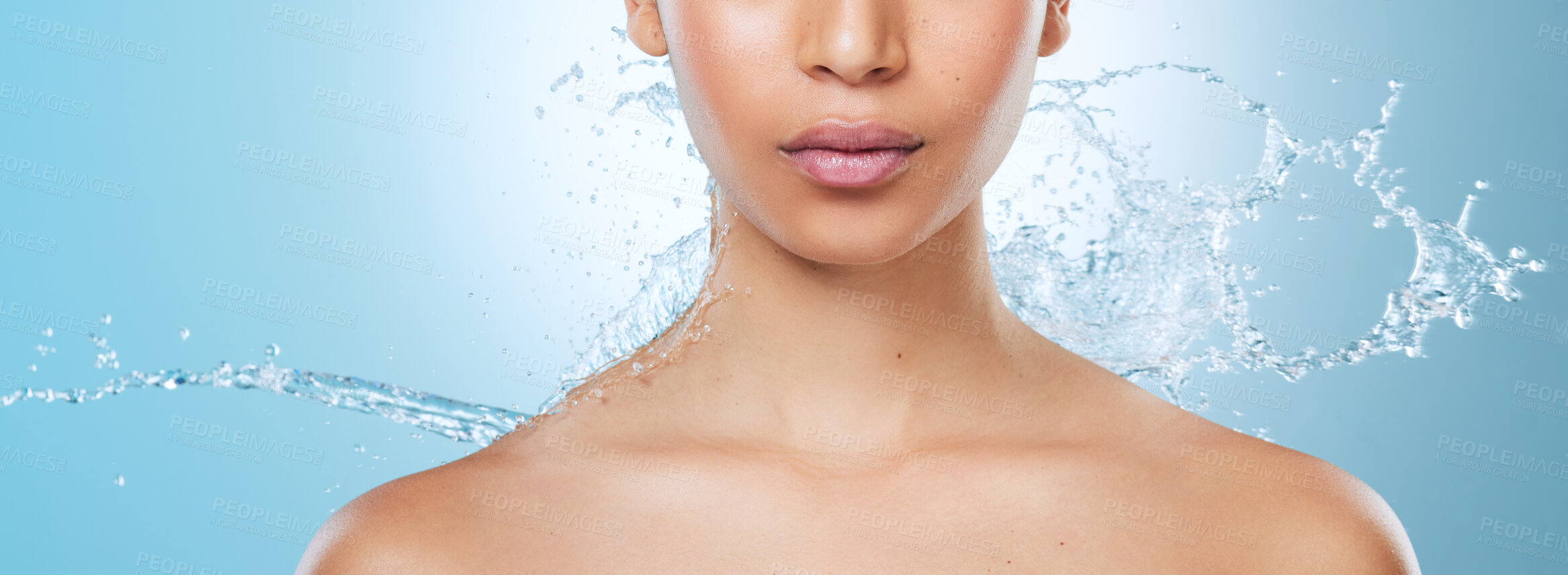 Buy stock photo Cropped shot of an unrecognisable woman posing against a blue background in the studio while being splashed with water