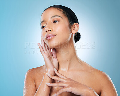 Buy stock photo Shot of an attractive young woman posing against a blue background in the studio
