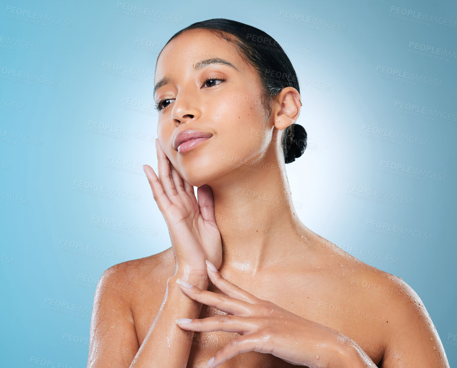 Buy stock photo Shot of an attractive young woman posing against a blue background in the studio