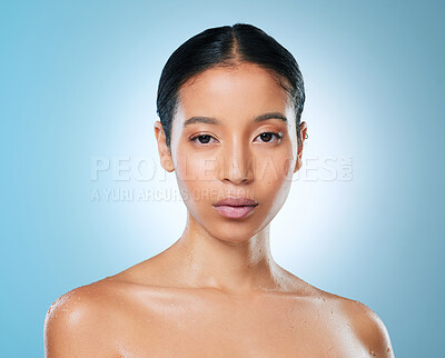 Buy stock photo Shot of an attractive young woman posing against a blue background in the studio