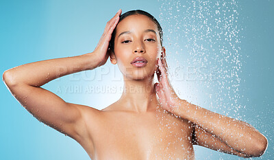 Buy stock photo Shot of an attractive young woman posing against a blue background while taking a shower
