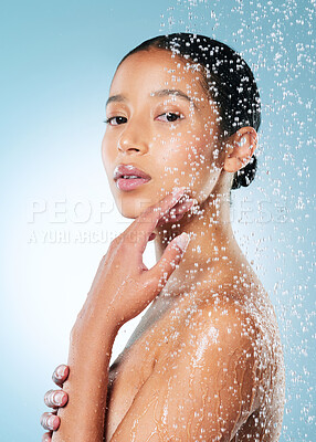 Buy stock photo Shot of an attractive young woman posing against a blue background while taking a shower