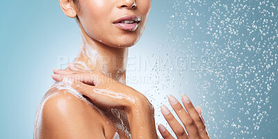 Buy stock photo Cropped shot of an unrecognisable woman using a body wash while taking a shower against a blue background