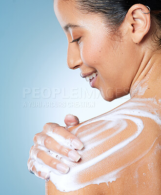 Buy stock photo Shot of an attractive young woman using a body wash while taking a shower against a blue background