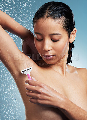 Buy stock photo Shot of an attractive young woman using a shaving stick to shave her underarms during her shower