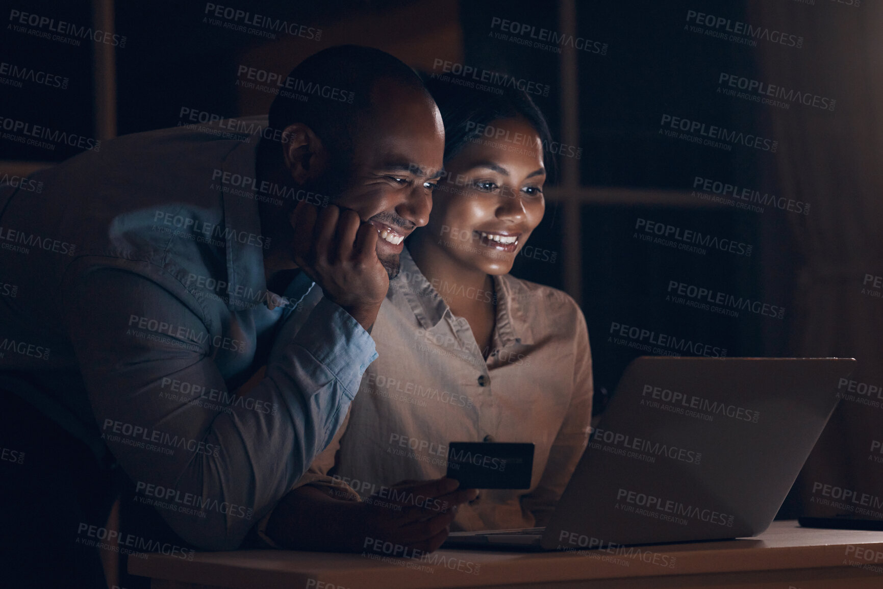 Buy stock photo Shot of a young man watching his wife make online payments using her bank card