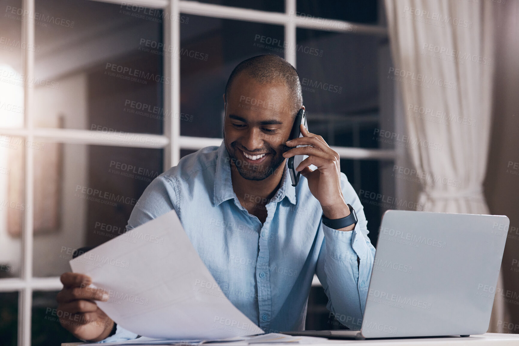 Buy stock photo Shot of a young businessman reading paperwork while making a phone call using his smartphone
