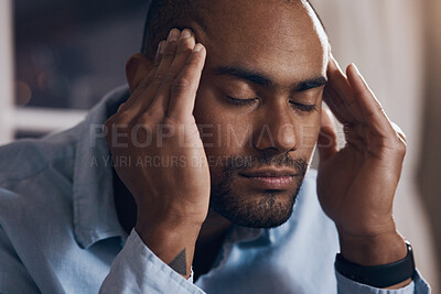 Buy stock photo Shot of a young businessman experiencing a headache while working