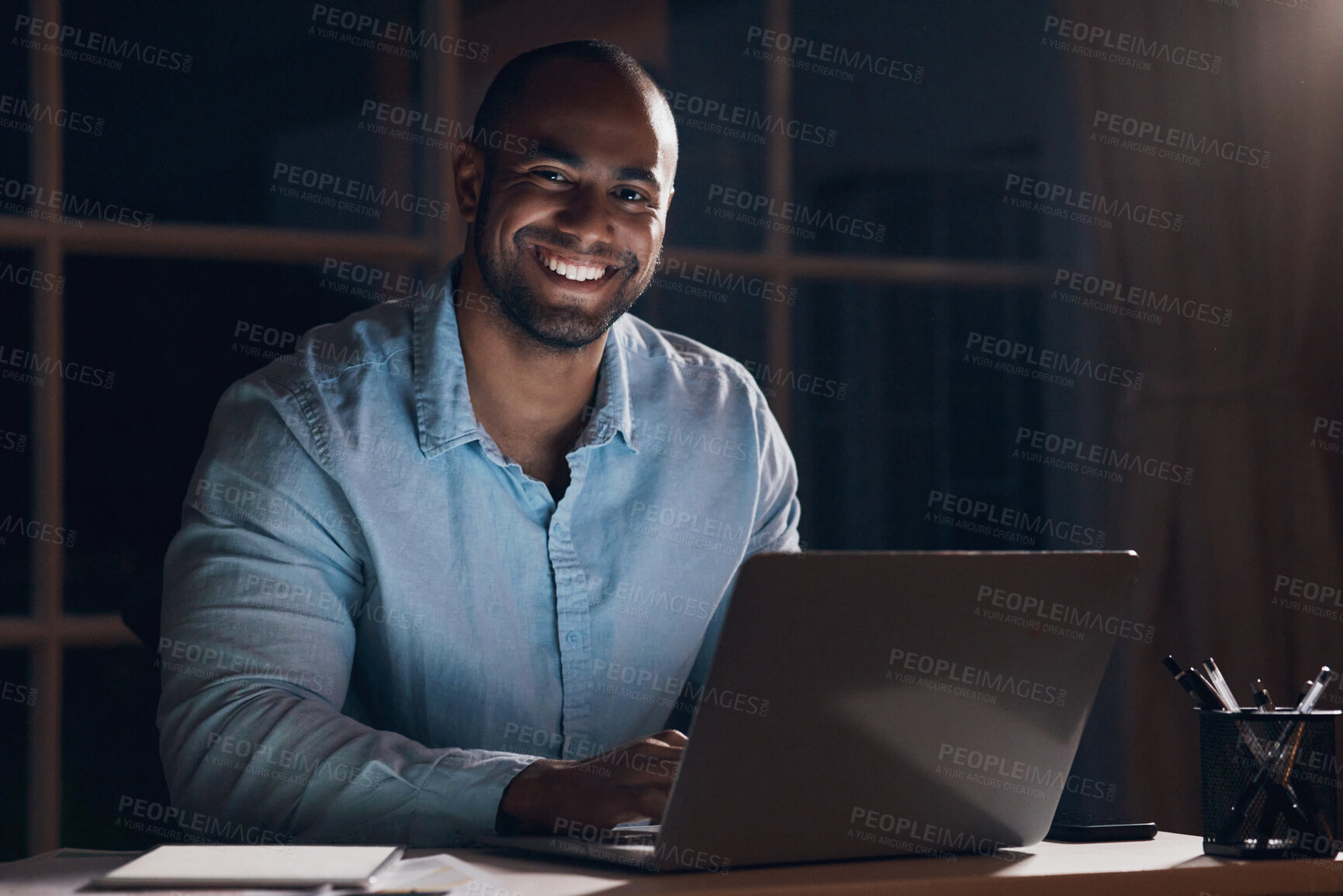 Buy stock photo Shot of a young businessman working on his laptop at night