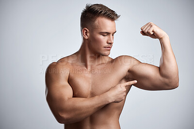 Buy stock photo Man, bodybuilder and pointing to bicep in studio, background and exercise for muscular power. Strong, sexy and topless male model, sports athlete and flex arm muscle with pride of fitness results