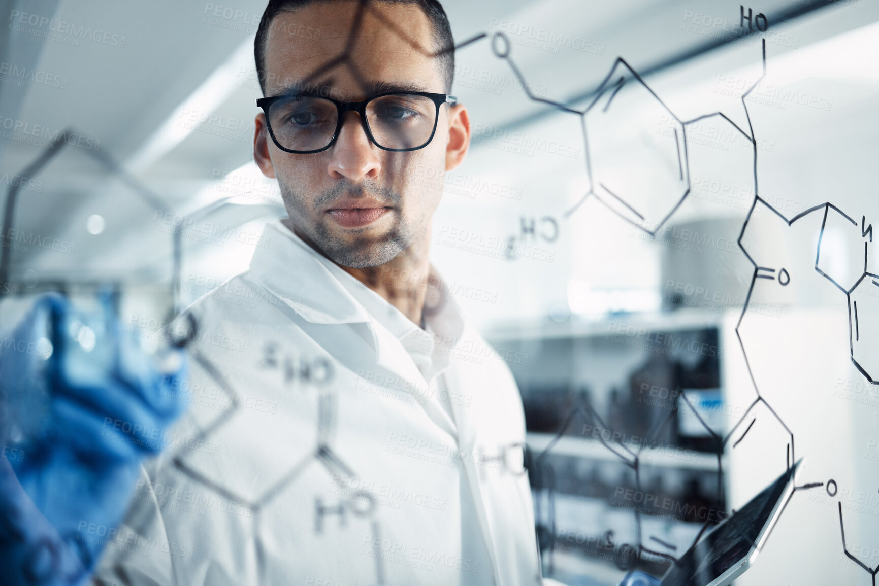 Buy stock photo Shot of a young scientist solving equations on a glass screen in a laboratory