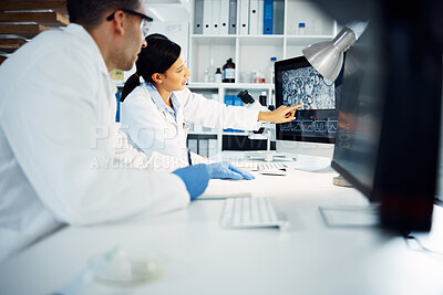 Buy stock photo Shot of two young scientists using a computer while conducting medical research in a laboratory