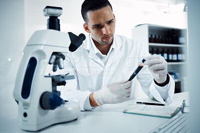 Buy stock photo Shot of a young scientist conducting medical research on blood in a laboratory