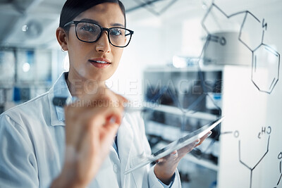 Buy stock photo Shot of a young scientist solving equations on a glass screen in a laboratory