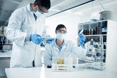 Buy stock photo Shot of two young scientists conducting medical research in a laboratory