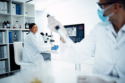 Buy stock photo Shot of two young scientists having a discussion while conducting medical research in a laboratory