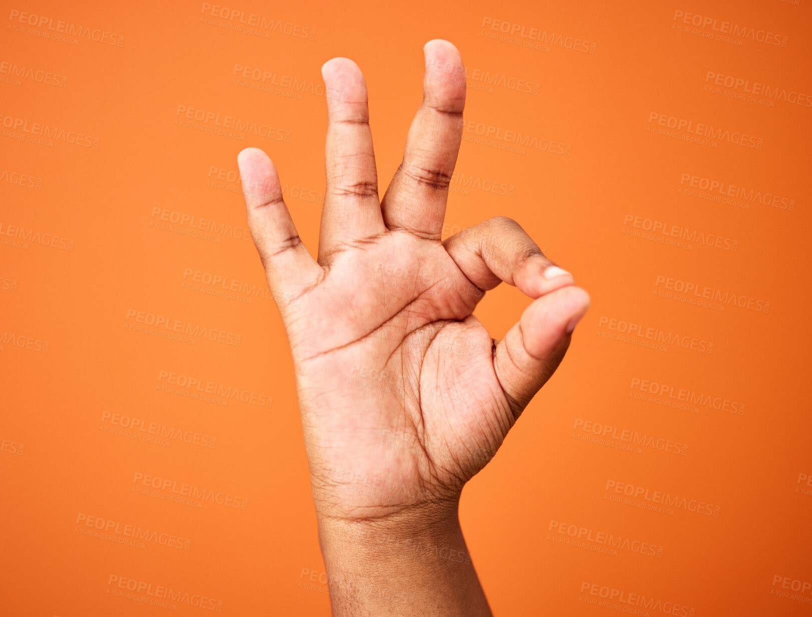 Buy stock photo Shot of an unrecognizable person showing a hand gesture against an orange background