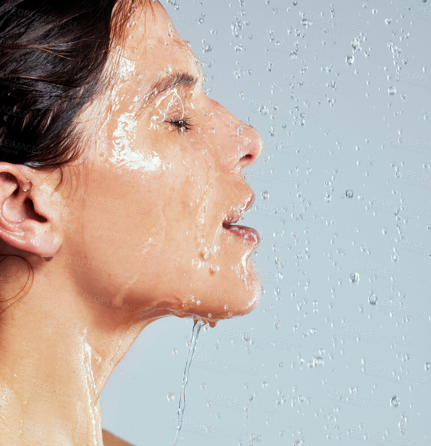 Buy stock photo Shot of a young woman taking a shower against a grey background