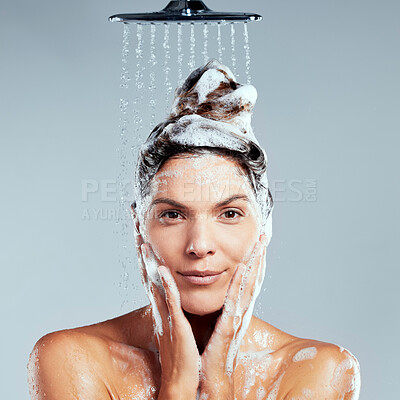 Buy stock photo Shot of a young woman washing her hair in the shower against a grey background