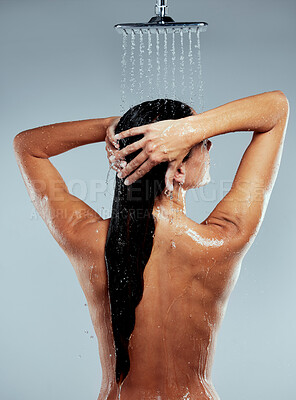 Buy stock photo Shot of an unrecognizable woman washing her hair in the shower against a grey background