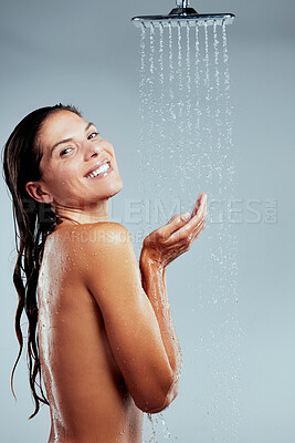 Buy stock photo Shot of a young woman taking a shower against a grey background