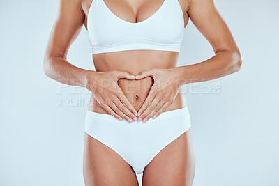 Buy stock photo Woman, heart and hands on stomach with diet, nutrition and gut health in studio background. Healthy, person and benefit for digestion with detox and girl healing colon IBS with holistic wellness