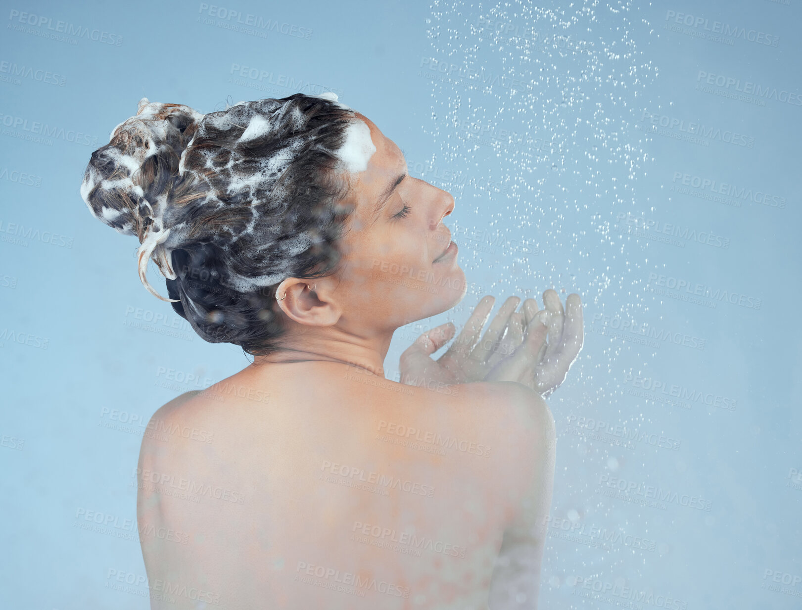 Buy stock photo Girl, shower and shampoo in studio for hair care with organic, eco friendly cosmetic and soap for treatment. Woman, isolated and blue background for hygiene with back, water and calm with eyes closed