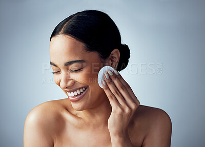 Buy stock photo Studio shot of an attractive young woman exfoliating her face against a grey background