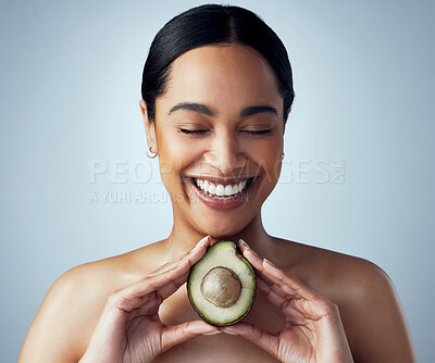 Buy stock photo Smile, hands and woman with avocado in studio for skincare, organic or facial on grey background. Face, avo and girl model with fruit for eco, vegan or detox with omega 3, collagen and vitamin c 