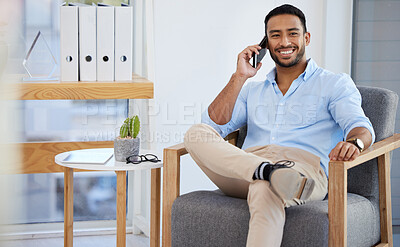 Buy stock photo Shot of a young businessman talking on a cellphone in an office