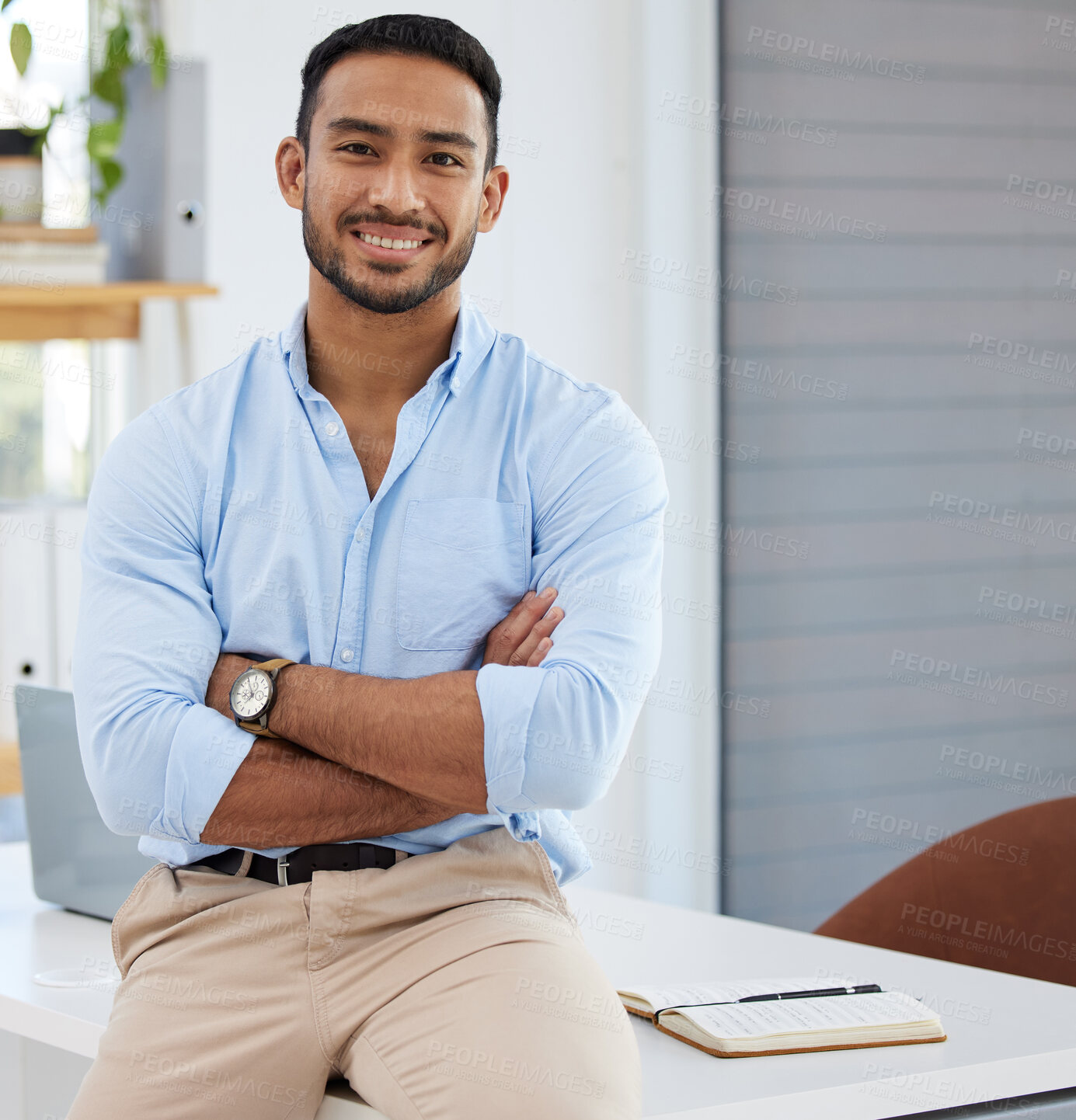 Buy stock photo Portrait of a confident young businessman standing with his arms crossed in an office