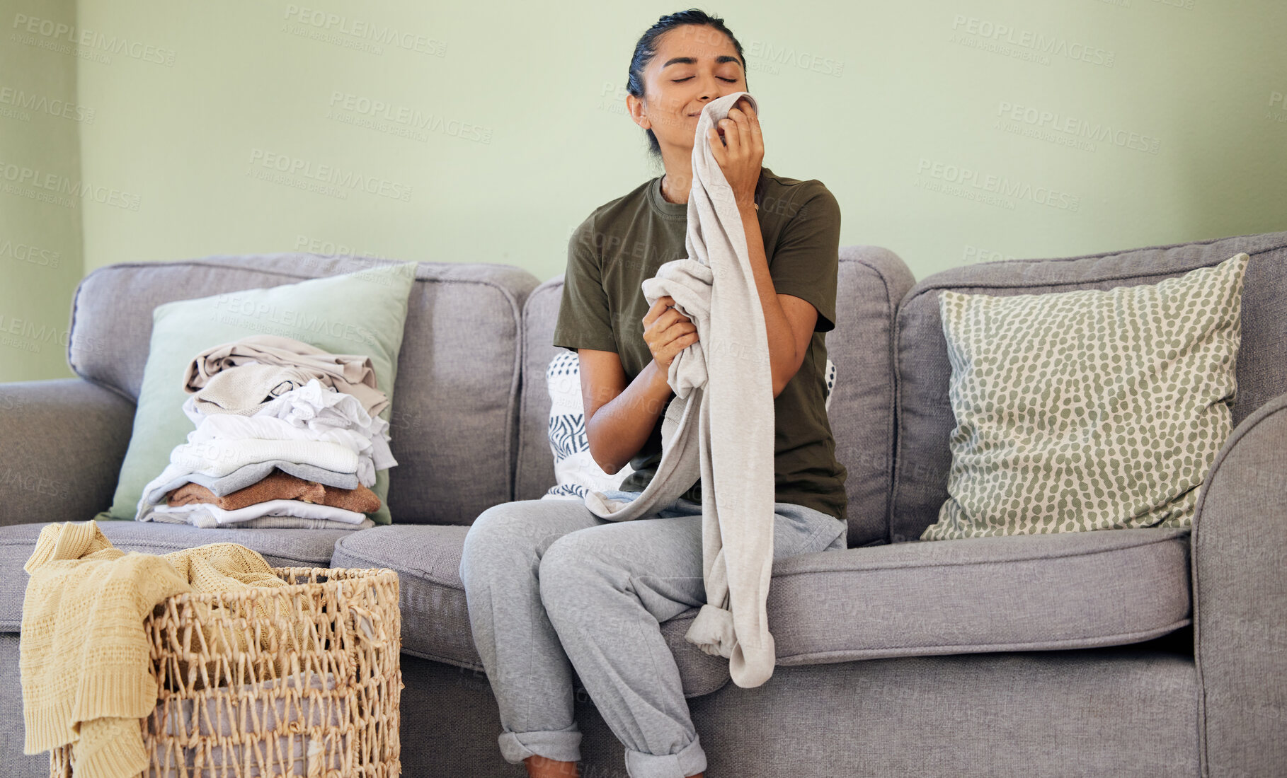 Buy stock photo Shot of a young woman organising laundry at home