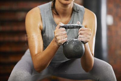 Buy stock photo Closeup shot of an unrecognisable woman exercising with a kettlebell in a gym