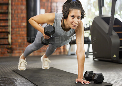 Buy stock photo Shot of a sporty young woman exercising with dumbbells in a gym