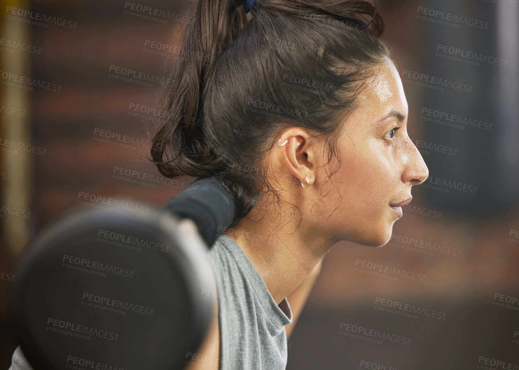 Buy stock photo Shot of a sporty young woman exercising with a barbell in a gym