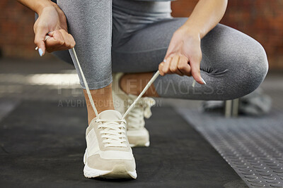 Buy stock photo Closeup shot of an unrecognisable woman tying her shoelaces while exercising in a gym