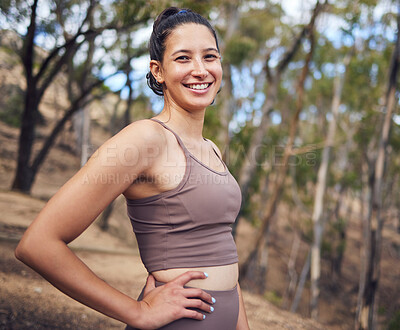 Buy stock photo Portrait of a sporty young woman standing with her hands on her hips while exercising outdoors