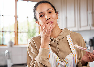 Buy stock photo Shot of a young woman tasting she made while baking