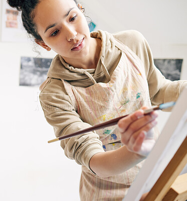 Buy stock photo Low angle shot of an attractive young woman painting on a canvas in her studio